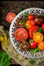 Tomatoes of different colors with green herbs in a bowl Royalty Free Stock Photo
