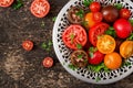 Tomatoes of different colors with green herbs in a bowl Royalty Free Stock Photo