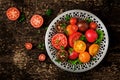 Tomatoes of different colors with green herbs in a bowl Royalty Free Stock Photo