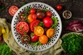 Tomatoes of different colors with green herbs in a bowl Royalty Free Stock Photo