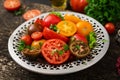 Tomatoes of different colors with green herbs Royalty Free Stock Photo