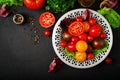 Tomatoes of different colors with green herbs Royalty Free Stock Photo