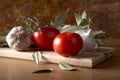 Tomatoes garlic and bay leaf branches on table Royalty Free Stock Photo