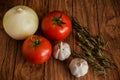 Tomato, garlic and onion on a wood background close-up table top Royalty Free Stock Photo