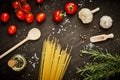 Tomatoes garlic salt olive peppers and pasta on a black table Royalty Free Stock Photo