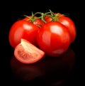 Tomatoes green twig with sliced halves on black