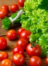 Tomatoes and green vegetables on wooden dark background Royalty Free Stock Photo