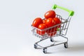 Tomatoes in a grocery cart. A shopping basket filled with fresh vegetables is isolated. The concept of healthy eating Royalty Free Stock Photo