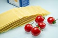 Tomatoes with lasagna on white reflexive glass