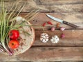 Tomatoes, leaves of onion and garlic on wood background