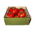 Tomatoes lie in a wooden box in straw isolated on white background Royalty Free Stock Photo