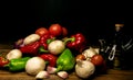 Tomatoes, mushrooms, red and green pepper, onion ,garlic and olive oil on a black background. Mediterranean food Royalty Free Stock Photo