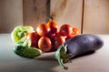 Tomatoes and other vegetables on a wooden table