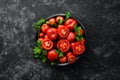 Tomatoes in a plate on a black stone background. Vegetables. Top view.