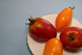 Tomatoes in a plate on a gray background.