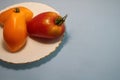 Tomatoes in a plate on a gray background.