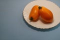 Tomatoes in a plate on a gray background.