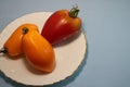 Tomatoes in a plate on a gray background.