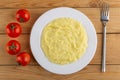 Tomatoes, plate with mashed potato, fork on table. Top view Royalty Free Stock Photo