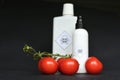 Tomatoes and poison bottle on black background