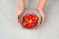 Tomatoes and red sliced pepper pieces in a bowl, prepare healthy food with paprika vegetables, holding fresh organic nutrition in Royalty Free Stock Photo