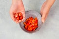 Tomatoes and red sliced pepper pieces in a bowl, prepare healthy food with paprika vegetables, holding fresh organic nutrition in Royalty Free Stock Photo