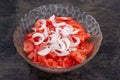 Tomatoes slices and onion in salad bowl on black surface Royalty Free Stock Photo