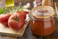 Tomatoes, tomato sauce, garlic, peppers and herbs over wood table Royalty Free Stock Photo