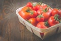 tomatoes in a wattled basket/tomatoes in a wattled box on a dark wooden background, selective focus and copyspace