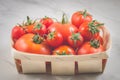 tomatoes in a wattled basket/tomatoes in a wattled basket on a marble background, selective focus