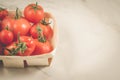 Tomatoes in a wattled basket/tomatoes in a wattled basket on a white marble background. Top view and copyspace