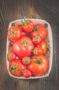 Tomatoes in a wattled basket/tomatoes in a wattled box on a dark wooden background, top view