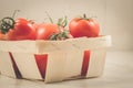 tomatoes in a wattled box/tomatoes in a wattled box on a white marble background Royalty Free Stock Photo