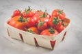 Tomatoes in a wattled container/tomatoes in a wattled container on a white marble background, selective focus