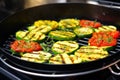 tomatoes and zucchini slices roasting in a grill wok Royalty Free Stock Photo