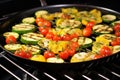 tomatoes and zucchini slices roasting in a grill wok Royalty Free Stock Photo