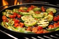 tomatoes and zucchini slices roasting in a grill wok Royalty Free Stock Photo