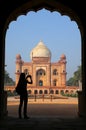 Tomb of Safdarjung seen from main gateway with silhouetted person taking photo, New Delhi, India