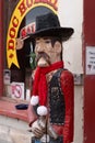 Rustic wooden carved statue of a wild west gunslinger cowboy outside a store in Tombstone