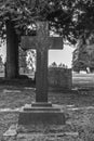 Tombstone and graves in graveyard landscape,black and white.