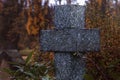 Tombstone in the shape of a cross in the cemetery. It`s raining outside Royalty Free Stock Photo