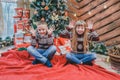 Full-length photo of funny kids in woolen sweaters imitating elephant ears with their hands and put tongues out, looking