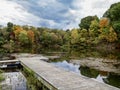 Tomlinson Run State Park in West Virginia in the fall with a boat dock in the foreground and colorful fall foliage trees in the