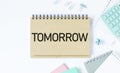 TOMORROW, text on white notepad paper