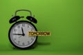 Tomorrow write on sticky note isolated green background. Procrastination or delay concept Royalty Free Stock Photo