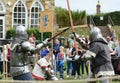 Combat fighter in medieval body armour strikes his opponent`s we