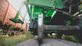 Toned closeup image of massive metal wheels and axle on cargo train car