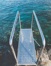 Toned closeup image of metal handrails and stairs on the cliff at ocean beach Royalty Free Stock Photo