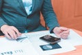 Toned Cropped image of businessman calculating invoice at desk in office