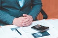 Toned Cropped image of businessman calculating invoice at desk in office